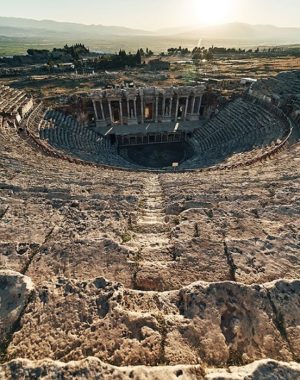 Ruins of ancient Hierapolis Amphi theatre with tourist Pamukkale, Denizili, Turkey. Evening sun