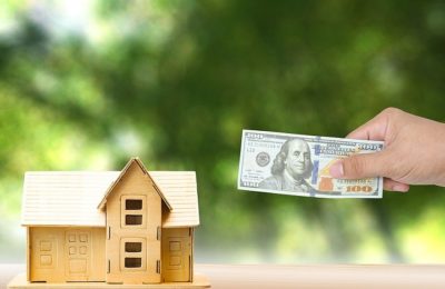 Home loan for real estate concept.A Human bringing money dollar to redeem the house Or take the house to apply for a bank loan.